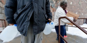 Residents carry free water being distributed at the Lincoln Park United Methodist Church in Flint, Michigan, on Feb. 3, 2015. It wasn&#039;t till October that the county declared a public health emergency.  